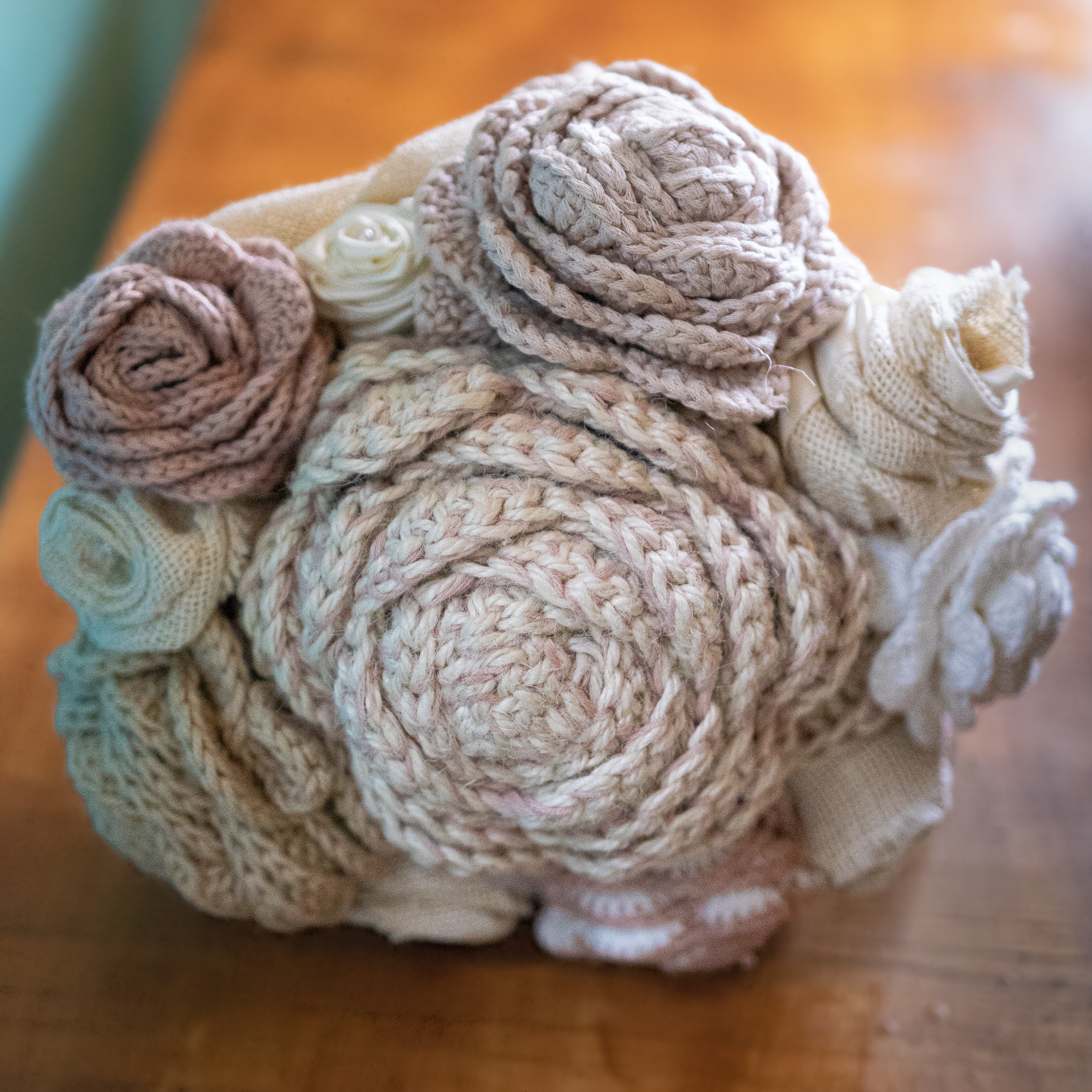 Close-up of a handmade crochet and textile wedding bouquet in soft neutral tones.